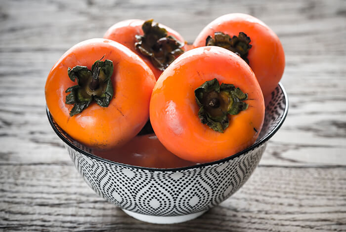 Persimmons fill up a bowl.