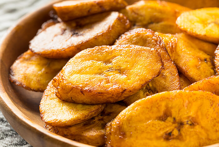 A plate full of sliced fried plantains.
