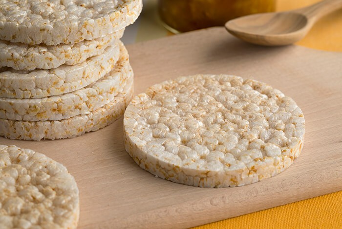 Stacks of rice cakes on a wooden chopping board.