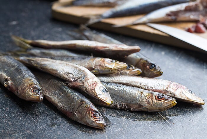 Cooked sardines on top of a granite surface.