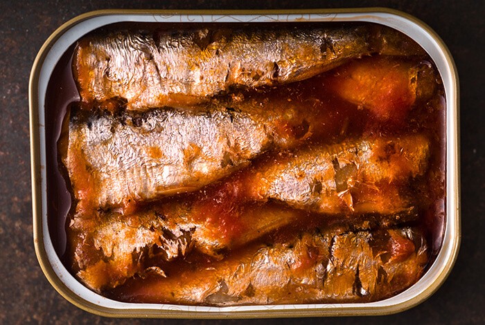 A tin can of cooked sardines with tomato sauce.