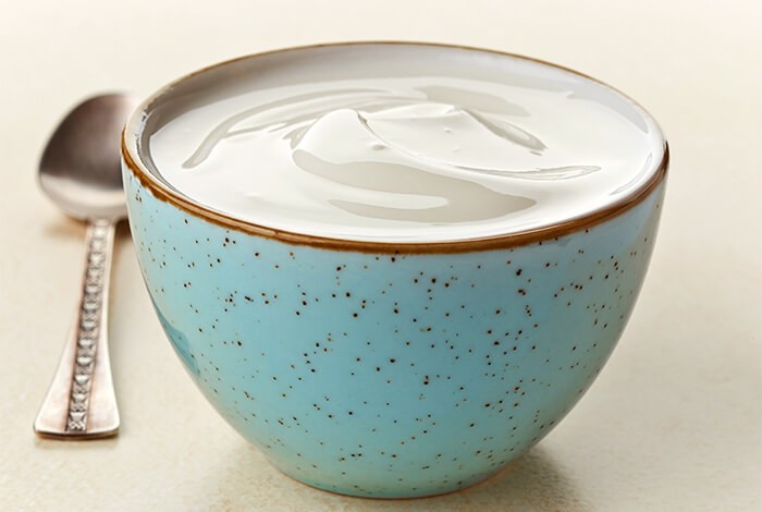 Plain yogurt in a blue ceramic bowl.