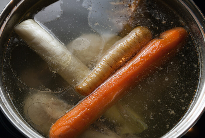 A pot filled with broth and vegetables.