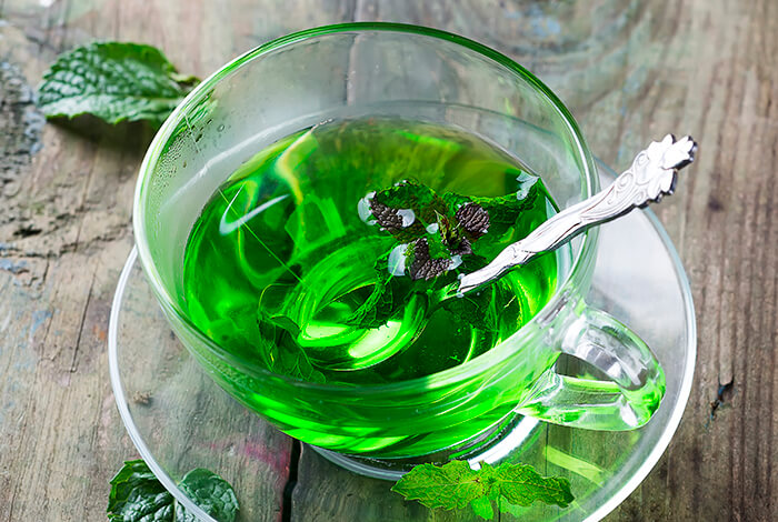 Fresh peppermint tea in a clear cup.