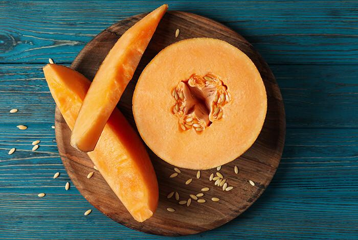 Sliced cantaloupes on a wooden surface.