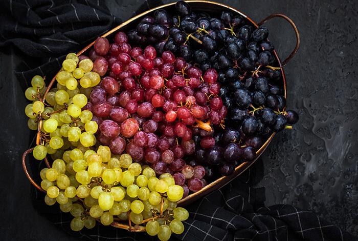 Different types of grapes displayed in basket.