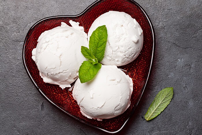 Dog yogurt ice cream with mint leaves on top and placed on a heart-shaped bowl.