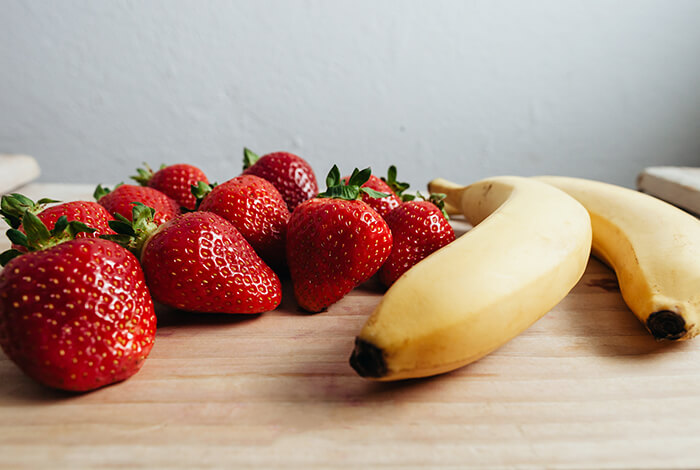 A bunch of strawberries and two bananas. 