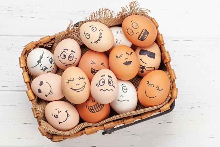 Organic eggs drawn with cartoon faces.