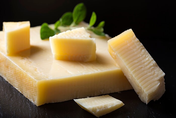 Different slices of cheddar cheese with herbs. 