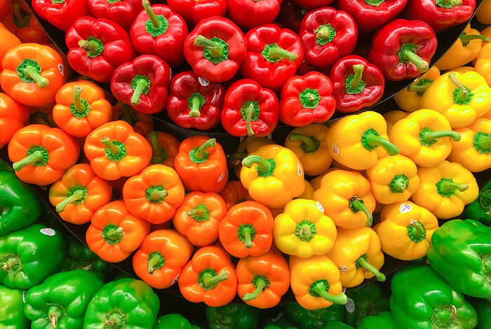 Bell peppers of different colors lined up for display.