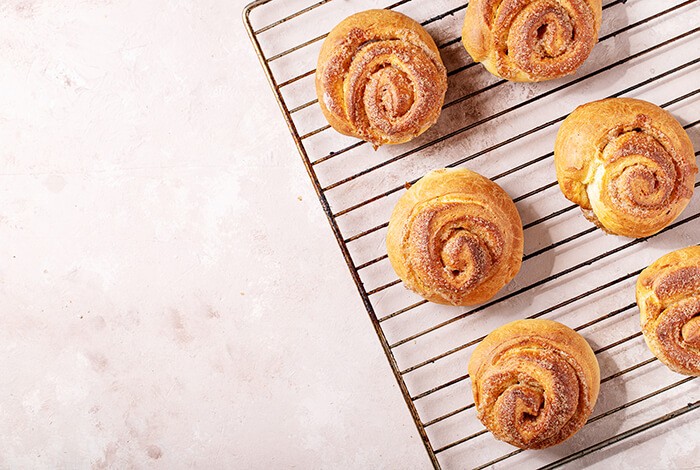 Cinnamon buns on a cooling rack.