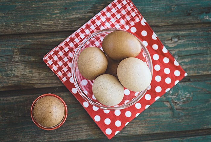 A glass bowl filled with eggs. 