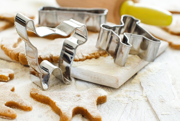 Cookie cutters shaped like a dog and cookie dough.