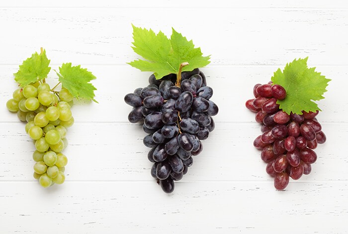 Bunches of white grapes, dark grapes, and regular grapes.