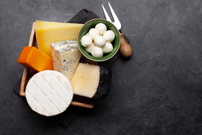 Different types of cheese placed in a wooden square box.