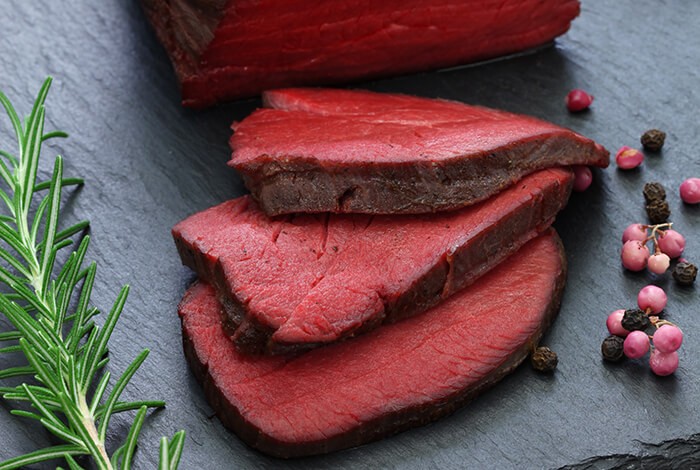 Slices of raw venison on a table.