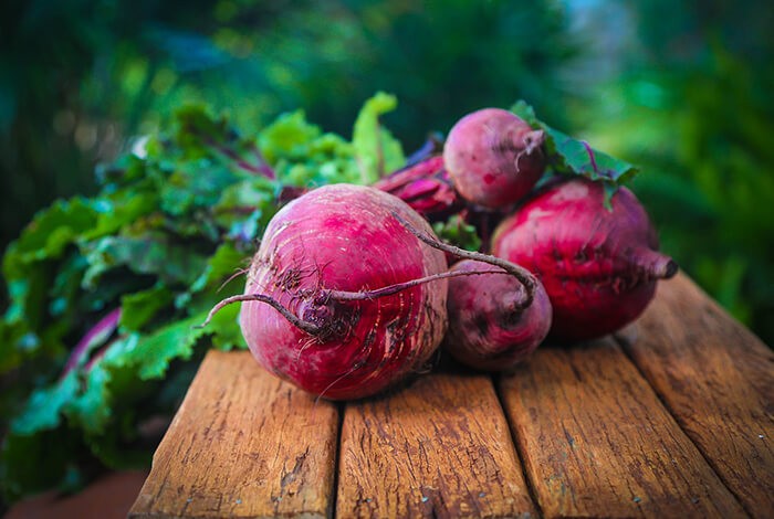 Beets placed on top of a wooden surface. 