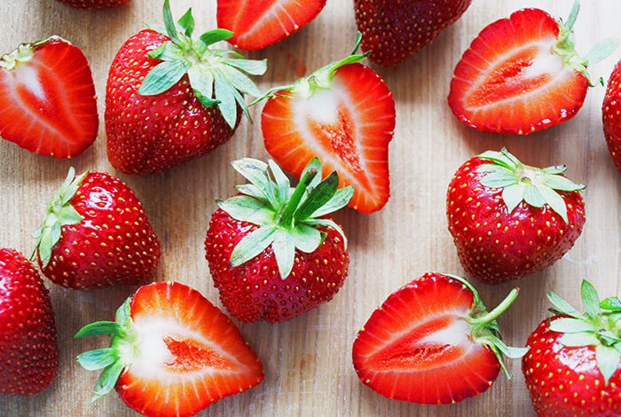 A close-up look at sliced and unsliced strawberries.