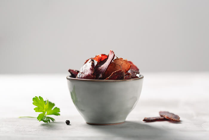 A bowl filled with duck jerky for dogs.