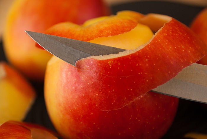 An apple peeled with a knife.