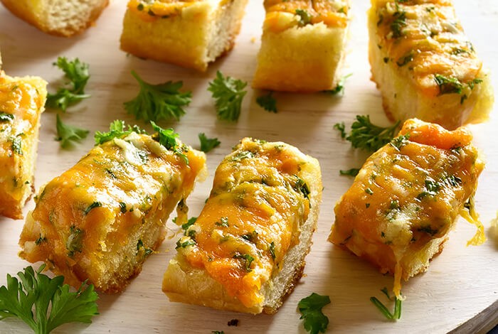 Pieces of bread with generous amounts of garlic and herbs.