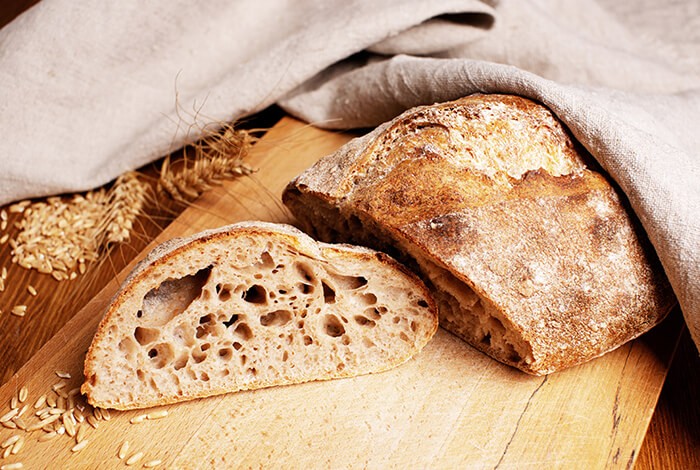 Slices of sourdough bread on a wooden chopping board.