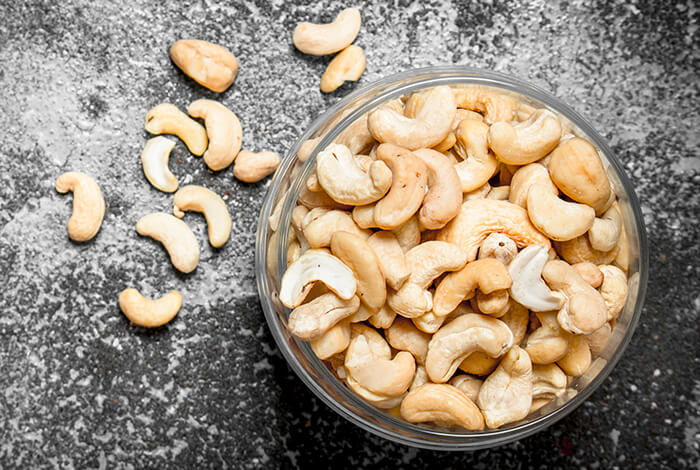 A glass bowl filled with toasted cashew nuts.