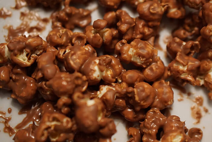 Chocolate-covered popcorn spread out on a surface.