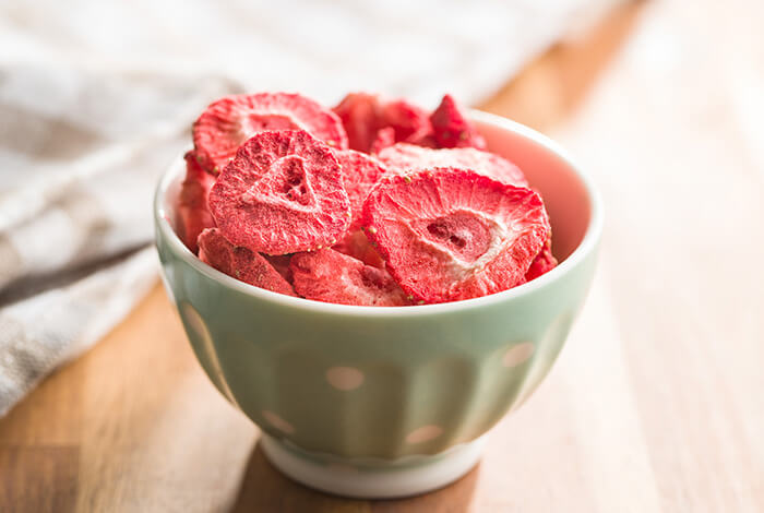 Slices of dried strawberries in a small ceramic bowl.