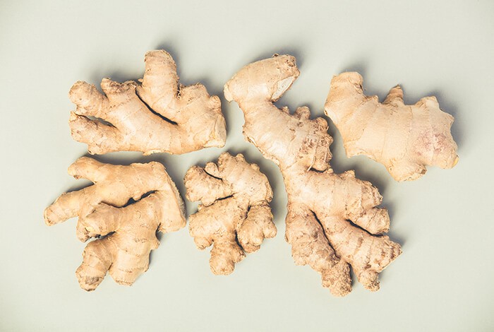 Pieces of ginger roots on top of a smooth surface.