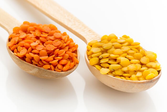 Two types of lentils filled two spoons.