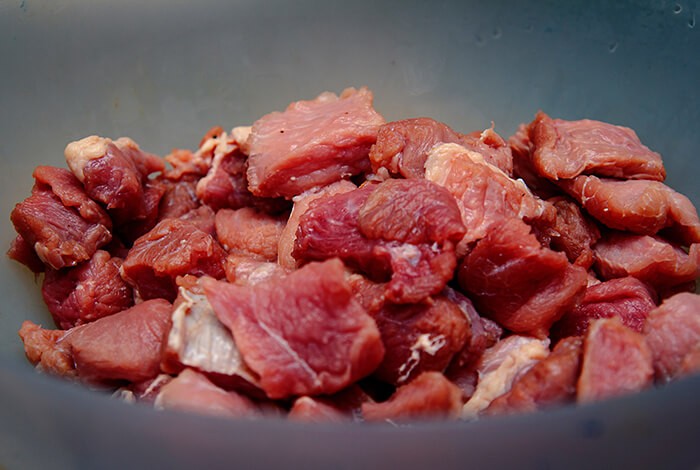 Pieces of raw pork in a bowl.