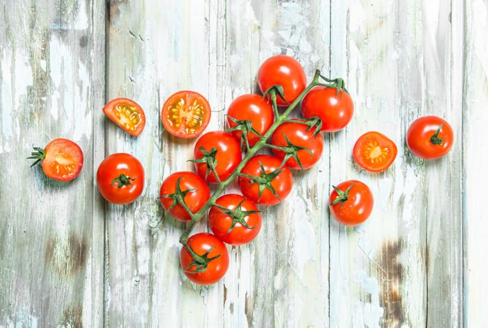 A branch of tomatoes and half slices of tomatoes. 