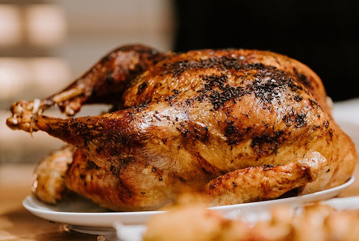 A roasted turkey presented on a dining table.