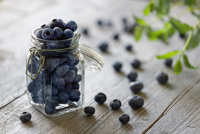 A small jar filled with blueberries.