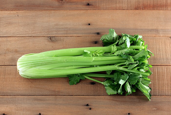 A celery on top of a wooden surface.