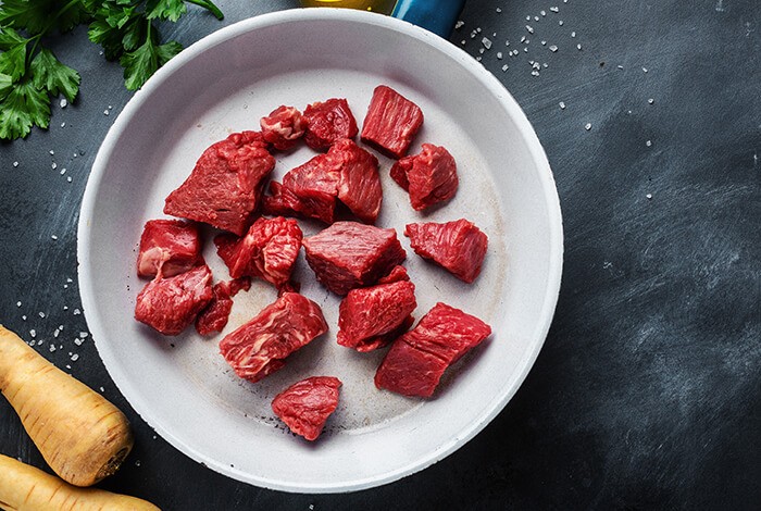 Diced kangaroo meat placed on a ceramic white plate.