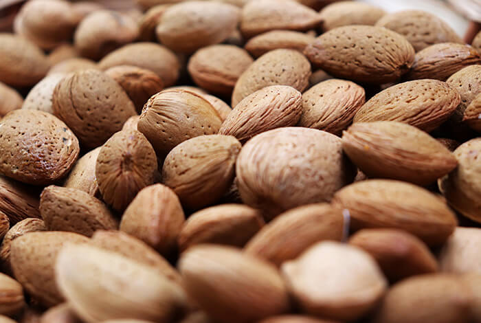 A close-up look at raw, uncracked almonds.