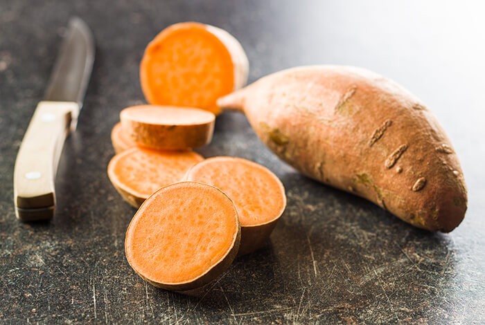 Slices of unpeeled, uncooked sweet potatoes.