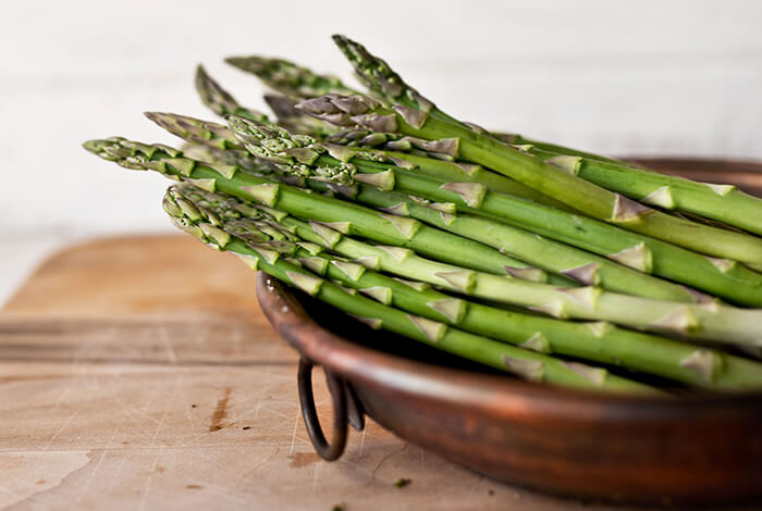 Raw asparagus on a pan.