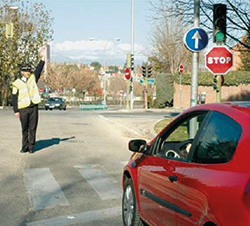 Imagen de la pregunta: En una intersección señalizada en la que se encuentra un agente regulando el trá
