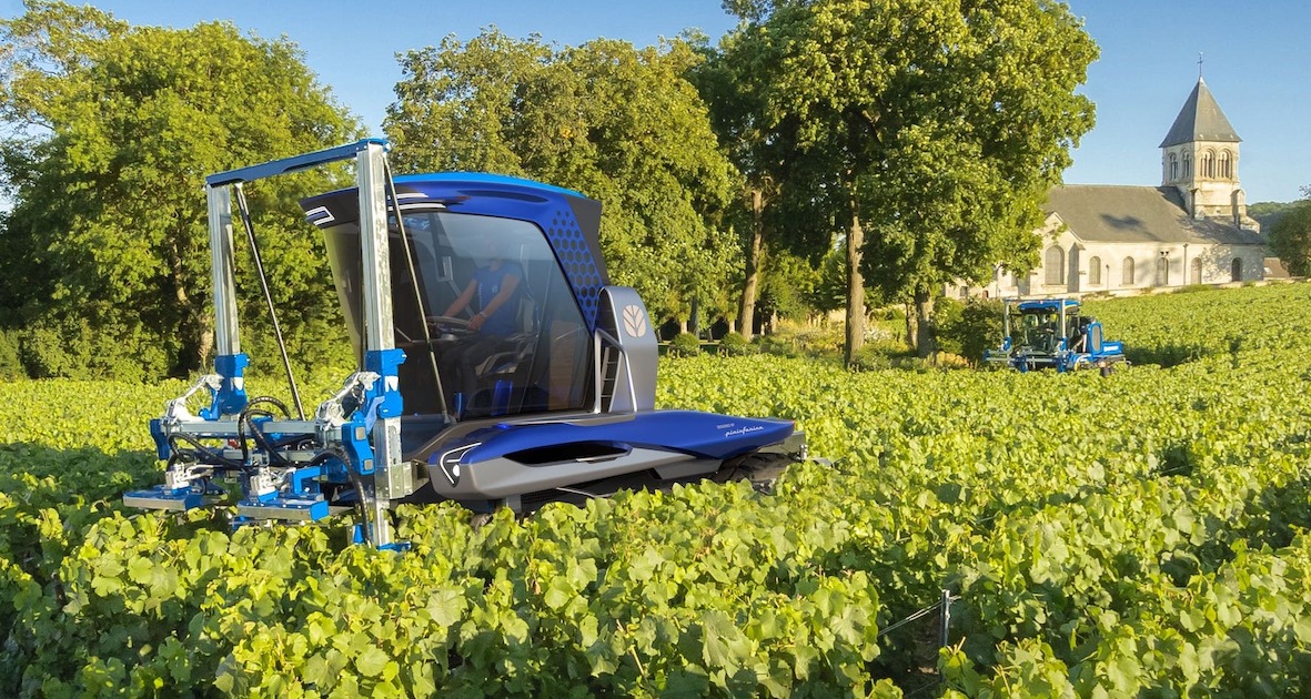 New Holland Straddle Tractor - trabalhando em vinhas perto de igreja