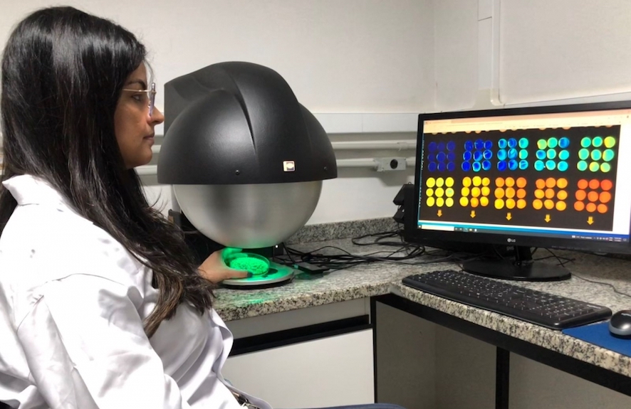 A pesquisadora Clíssia Barboza da Silva capturando imagens da fluorescência de clorofila em sementes de soja usando o equipamento VideometerLab4. - Foto: Thiago Barbosa Batista/Unesp