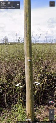 United Kingdom clue: Small circle attachments on wooden utility poles