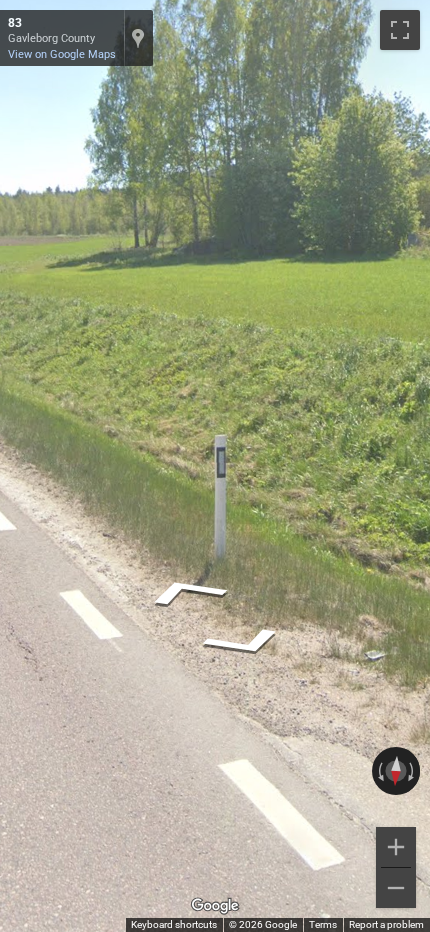 Swedish bollard with a flat top and a grey rectangular reflector on a straight black stripe.
