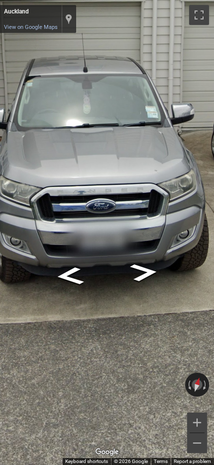 New Zealand white license plate with black text, noticeably shorter than typical European vehicle registration plates.