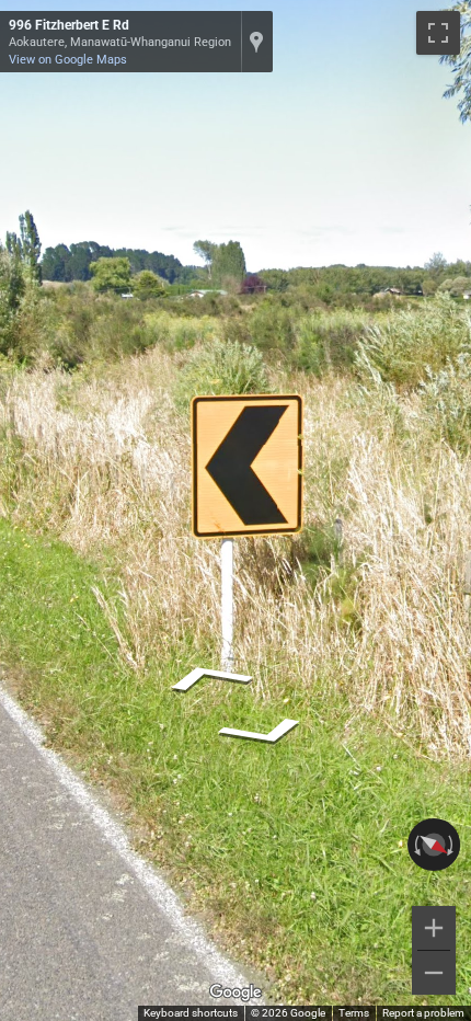 New Zealand black and yellow chevron sign with a thin black border, indicating a sharp curve ahead.