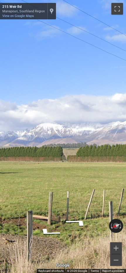 New Zealand snow-capped mountains rise majestically, with clear blue skies above and green valleys below.