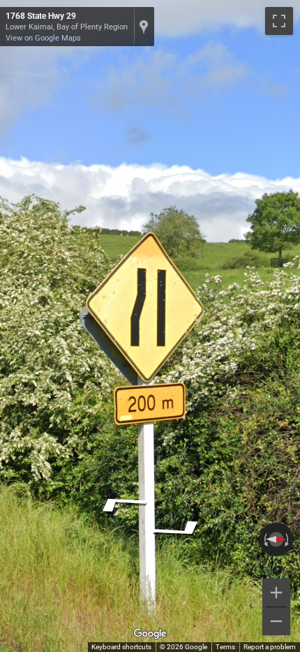 New Zealand yellow diamond-shaped road sign used for warnings or directions, often seen on rural roads.